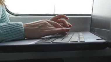 Tren içinde laptop klavye yazarak eller. Kadın demiryoluna seyahat sırasında arkadaşlarınızla sohbet. Dizüstü bilgisayar kullanan genç kız. Kol bir ileti yazdırır. Yakın çekim