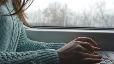 Tren içinde laptop klavye yazarak eller. Kadın demiryoluna seyahat sırasında arkadaşlarınızla sohbet. Dizüstü bilgisayar kullanan genç kız. Kol bir ileti yazdırır. Yakın çekim