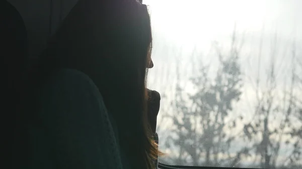Mujer joven mirando por la ventana durante el viaje en tren. Perfil de chica atractiva que viaja en ferrocarril — Foto de Stock