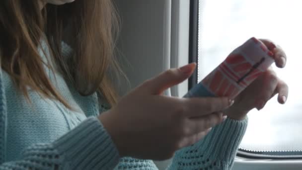 Mujer joven viajando en un tren y utilizando el teléfono móvil. La mano femenina envía un mensaje desde el teléfono inteligente. Brazo de chica charlando con amigos. De cerca. — Vídeos de Stock