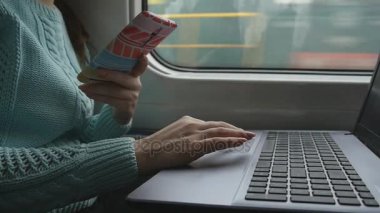 Touchpad laptop pc ve smartphone içinde treniyle eller. Kol genç kadının üzerinde demiryolu seyahat sırasında dokunmatik dizüstü dokunmadan. yakın çekim. Ağır çekim