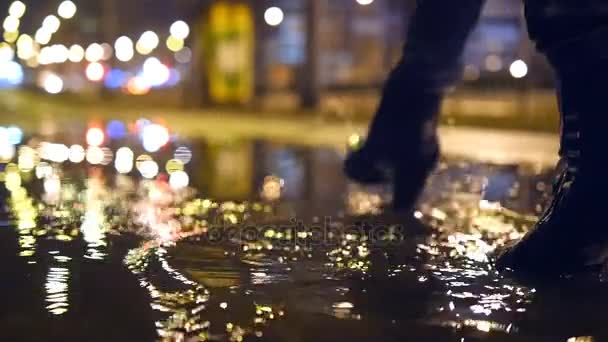 Close up slow motion shot of womans legs stepping into muddy puddle and making splash — Stock Video