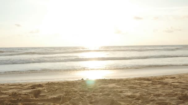 Sonnenuntergang am Strand - ruhige idyllische Szenerie eines goldenen Sonnenuntergangs über dem Meer, Wellen plätschern langsam auf dem Sand. Sonnenaufgang über dem Ozean. Zeitlupe — Stockvideo