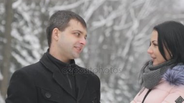 Genç yakışıklı esmer kız ve erkek arkadaşı parkta sohbet. Aşıklar Parkı ve konuşma, kahkaha, öpücük tribünde