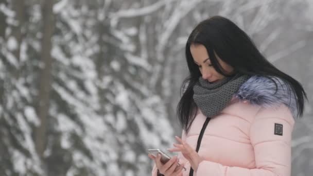 Mooi meisje permanent op straat en gebruik maken van haar telefoon om te chatten — Stockvideo