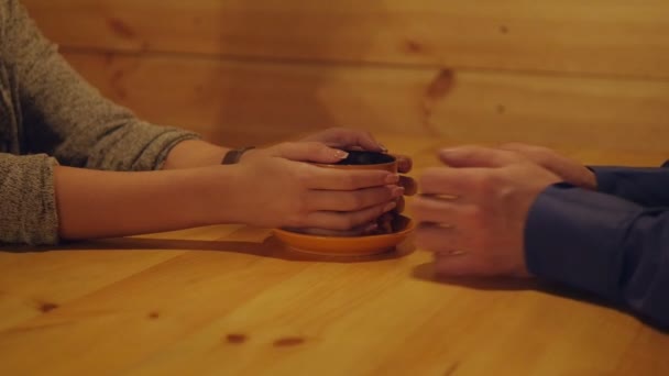 Coppia amorevole seduta in un caffè. L'uomo tocca delicatamente la fidanzata. Primo piano mostrando le mani di giovani uomini e donne — Video Stock