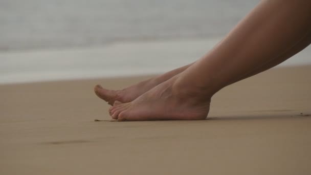 Όμορφη νεαρή γυναίκα ξαπλωμένη στη χρυσή άμμο στην παραλία και χαλάρωση κατά τη διάρκεια ταξίδια-διακοπές το καλοκαίρι. Σέξι γυναικείο σώμα. Κοντινό πλάνο — Αρχείο Βίντεο