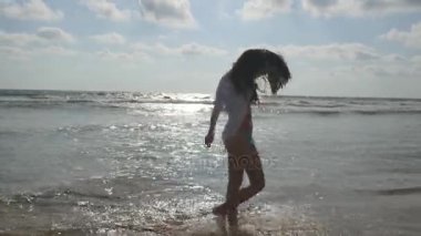 Mutlu kadın bikini ve okyanus su kumsalda yürüyüş gömlek. Genç güzel kız hayattan zevk ve deniz sahilinde eğleniyor. Yaz tatili ya da tatil