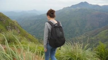 Genç kadın turist ile güzel doğa manzara arka plan, iz Dağları'nda, yürüme sırt çantası ile. Kadın uzun yürüyüşe çıkan kimse dar Zirvesi ridge kret gidiyor. Sağlıklı aktif yaşam tarzı. Ağır çekim
