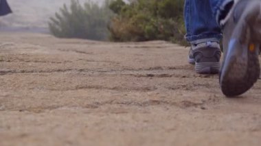 İki erkek turizm taş köprüde açık yürüyüş ayak. Bacaklar erkeklerin güzel doğa, kayalık iz oluyor. Dağlar seyahat sırasında adım çocuklar. Sağlıklı bir yaşam tarzı. Yakın çekim