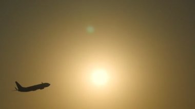 Yolcu uçak silueti güneşi batarken uçar. Gündoğumu geçmiş vasıl kalktıktan uçak. Uçak kapısı güzel sabah gökyüzü güneş doğarken. Ağır çekim yakın çekim