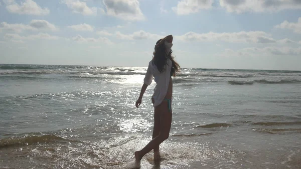 Mutlu kadın bikini ve okyanus su kumsalda yürüyüş gömlek. Genç güzel kız hayattan zevk ve deniz sahilinde eğleniyor. Yaz tatili ya da tatil