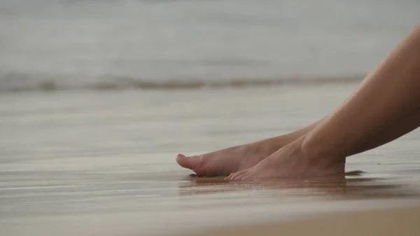 Mooie jonge vrouw liggend op het gouden zand op zee strand en ontspannen tijdens zomer vakantie reizen. Sexy vrouwelijk lichaam. Close-up — Stockfoto