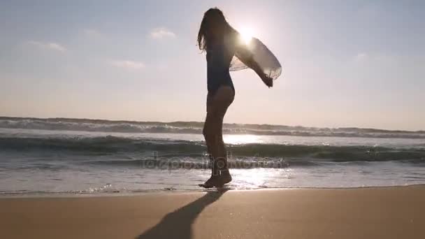 Mujer feliz caminando y girando en la playa cerca del océano. Joven hermosa chica disfrutando de la vida y divertirse en la orilla del mar. Su — Vídeos de Stock