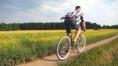 Kırsal alanda bisiklet süren genç bir adam var. Sportif adam şehir dışında bisiklet sürüyor. Erkek bisikletçi kırsalda bisiklet sürüyor. Sağlıklı aktif yaşam tarzı Yavaş çekim