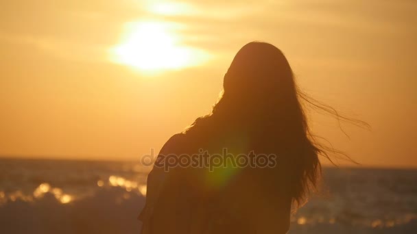 Oigenkännlig unga resenären kvinna kommer på stranden i soluppgången. Ung kvinnlig turist med ryggsäck promenader längs stranden i solnedgången. Flicka hiker kliva under sommarlovet. Slow motion — Stockvideo