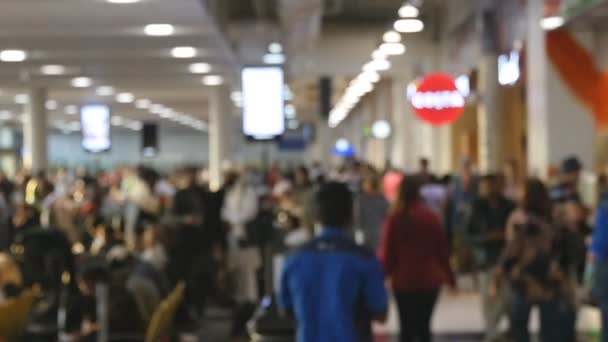 Folk går på flygplatsen. Oskärpa bakgrund från upptagen stor flygplats med människor som går längs väntar hal. Långsamma rörelser — Stockvideo