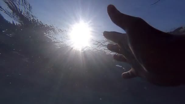 Oogpunt van man verdrinkt in de zee of de Oceaan. Arm om hulp te vragen en te proberen om de zon te bereiken. Mannenhand strekt zich onder het water zonnestralen. Slow motion Pov — Stockvideo