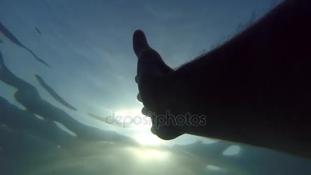 A mão masculina estende-se desde debaixo da água até aos raios solares. Braço pedindo ajuda e tentando alcançar o sol. Ponto de vista do homem se afogando no mar ou no oceano e flutuando para a superfície. POV em câmara lenta — Vídeo de Stock