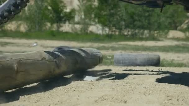 Motocross rider supera la barrera del tronco de madera. Las ruedas de enduro superan el obstáculo. Primer plano: cámara lenta — Vídeos de Stock