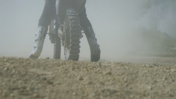 Coureur de motocross commencer à monter à son vélo de saleté botter la saleté et la poussière. Vue arrière Mouvement lent — Video