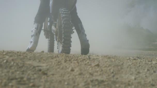 Motocross racer start riding at his dirt bike kicking up dirt and dust. Back view Slow motion — Stock Video