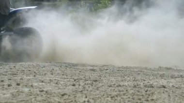 Atv motorcu başında yüksek hız, kir ve toz tekme girer. Ağır çekim yakın çekim