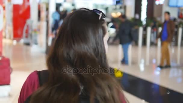Aanleiding tot jong meisje wandelen langs de luchthaventerminal. Vrouw gaan door winkelcentrum. Achteraanzicht van de achterzijde — Stockvideo