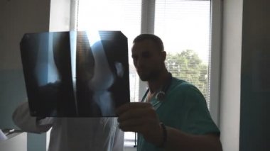 İki beyaz doktor MRI resim ve bu konuda tartışmaya görüntüleyin. Hastanede tıbbi işçi x-ışını baskılar inceleyin. Erkek sağlık görevlilerinin birbirleri ile x ışını Image'da bakarken bakın. Yakın çekim