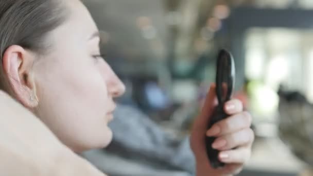 Giovane donna che si guarda allo specchio e corregge i capelli. Cura dei capelli Close up — Video Stock