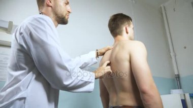 Doktor genç erkek hastanın omurga incelenmesi. Tıbbi işçi tanı atletik erkek gövdesi. Adam hastanede ofisinde arka kontrol doktor. Yakın çekim