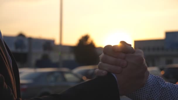 Amichevole stretta di mano di due uomini d'affari irriconoscibili in ambiente urbano. Stringi la mano all'aperto. Scuotimento delle braccia maschili all'esterno. I colleghi si stringono la mano sullo sfondo della città. Chiudere rallentatore — Video Stock