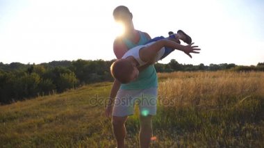 Baba ve oğul günbatımında sahada oynuyor. Mutlu baba küçük çocuğunu elinde döner. Çocuk gibi bir uçak uçar hayal. Mutlu bir aile vakit açık. Aktif yaşam tarzı. Ağır çekim