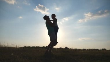 Mutlu baba küçük oğlunu atma. Baba ve oğul günbatımında sahada oynuyor. Baba ve çocuk birlikte eğleniyor. Ağır çekim