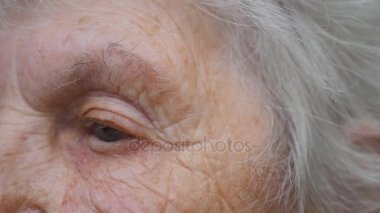 Yaşlı kadın gözlük ve mesafe içine bakarak koyar. Büyükanne gözlük takıyor. Büyükanne portresi. Yavaş hareket kapatmak