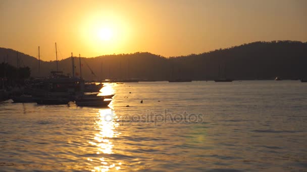 Siluety rybářských člunů, stojící poblíž pobřeží při západu slunce. Rybářská plavidla kýval na vlnách v krásný večer. Přírodní pozadí. Krásná krajina. Zpomalený pohyb — Stock video