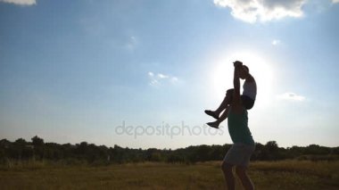 Baba ve oğul günbatımında sahada oynuyor. Güzel manzara yürürken babasının omuzlarında oturan çocuk. Mutlu bir aile açık havada zaman harcama. Aktif yaşam tarzı. Ağır çekim