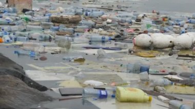 Çevre kirliliği. Plastik şişeler, torbalar, çöpler nehirde, gölde. Suda yüzen çöp ve kirlilik