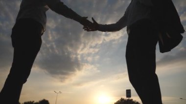 Toplantı ve kentsel ortamda birbirlerini tebrik iki iş adamları. İş karşılıklı açık. Erkek silah sallayarak. İş arkadaşları şehir arka planda el sıkışın. Yavaş hareket kapatmak