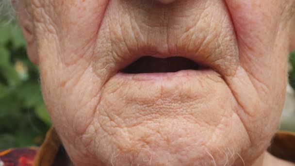 alte Frau, die sich weiße Pillen in den Mund steckt. Großmutter nimmt Tabletten, die ihre gesundheitlichen Probleme lindern. Gesundheitswesen und medizinisches Konzept. Zeitlupe in Nahaufnahme