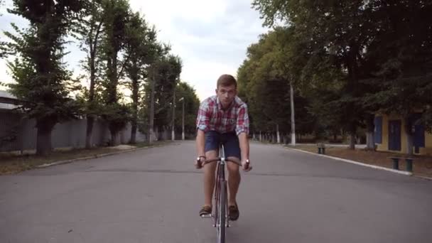 Portrét mladíka šťastný vintage jízdou na silnici parku. Sportovní chlap Cyklistika venkovní a úsměv. Zdravý aktivní životní styl. Čelní pohled zblízka zpomalené — Stock video