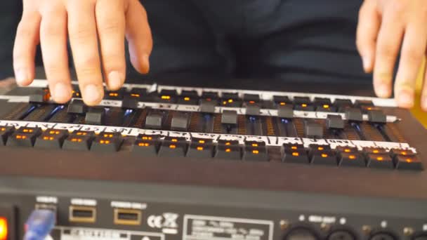 男性のサウンド エンジニアの手はキーを押したし、響板のボタンを移動します。プロフェッショナル デジタル オーディオ ミキサーで作業する人の腕の中。アンプと音のバランス。スローモーションを閉じる — ストック動画