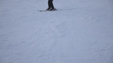 Dağ karlı yamaç azalan tanınmaz halde kadın kayakçı metrelik. Tepe Kayak merkezinde üzerinde aşağı kayan genç kız. Kış soğuk havalarda. Tatil veya tatil kavramı. Yan görünümü ağır çekim