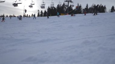 Kayakçı ve dağ karlı yamaç azalan snowboard düşkünleri. Teleferik Hill sürme insanlar. Güzel kış manzarası. Tatil veya tatil kavramı. Düşük açılı görünüş ağır çekim