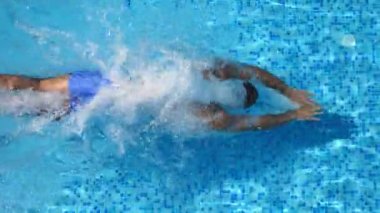Üstten Görünüm tanınmaz halde sportif adamın Havuzu Açık mavi suya atlama. Genç kas adam otel Havzası güneşli günde yüzer. Yaz tatili veya tatil kavramı. Yakın çekim