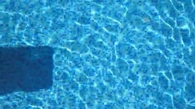 Güzel tabaklanmış kız güneş gözlüğü ve pembe bikini yüzme havuzunda sarı şişme yatak yatan bir üstten görünüm. Genç kadın rahatlatıcı Havzası otelinin yaz seyahat sırasında. Tatil kavramı