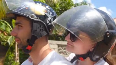 Profil tropik ülke yol boyunca bir scooter sürme kask genç çiftin. Gülümseyen erkek ve kadın üzerinde motorlu bisiklet yaz tatili seyahat. Selfie sırasında seyahate mutlu çifti. Yakın çekim