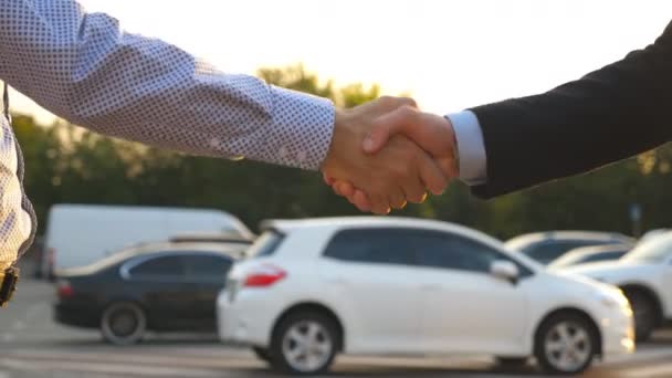 Férfi kezek öltönyben, kocsikulcsokat ad a barátjának. Egy üzletember átadja a kocsikulcsot. Kézfogás két üzletember között odakint. Lezárás Lassú mozgás — Stock videók