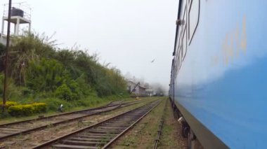 Eski mavi tren geçerken küçük köyde sabah kapılardan düşük açılı manzara. Yolcu demiryolu taşımacılığı güzel doğal kırsal taşıma. Seyahat kavramı. Yakın çekim