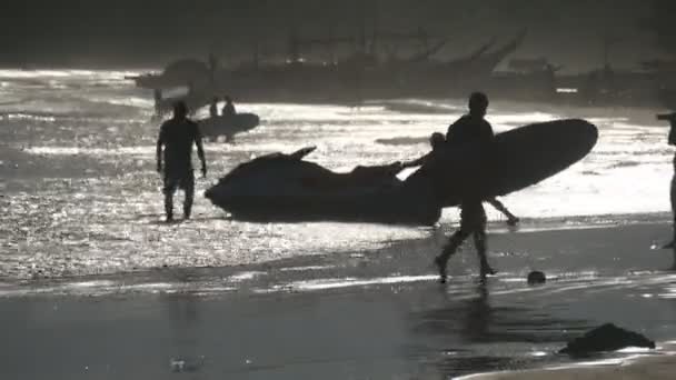 Silueta k nepoznání mladý muž na tropické pláži Surf při západu slunce. Krásný pohled krajina. Letní dovolenou nebo dovolenou koncept. Zadní pohled zezadu — Stock video